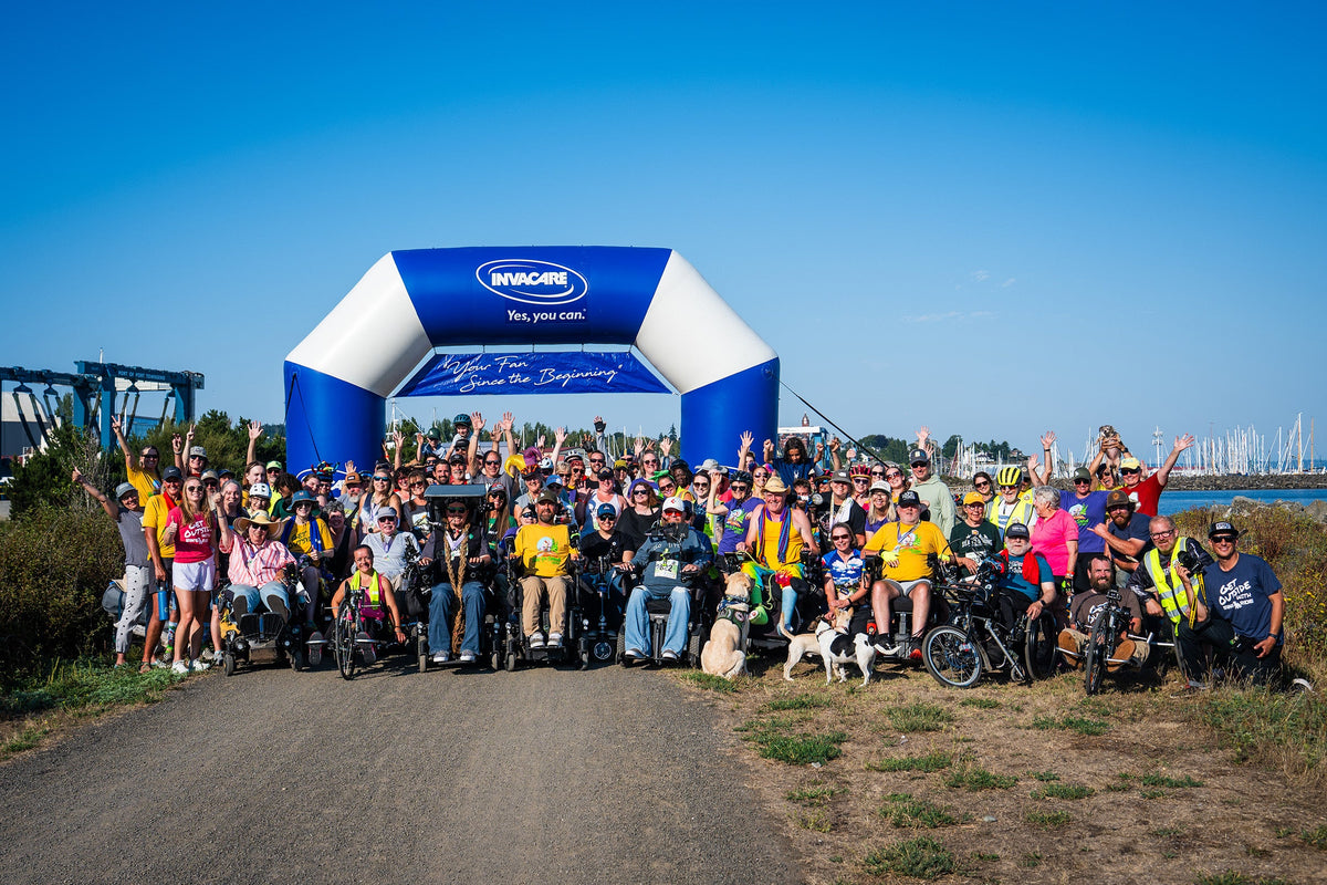Group photo of Sea to Sound participants, including wheelchair users, adaptive athletes, volunteers, and supporters gathered at the event start line to celebrate accessibility, inclusion, and outdoor recreation.