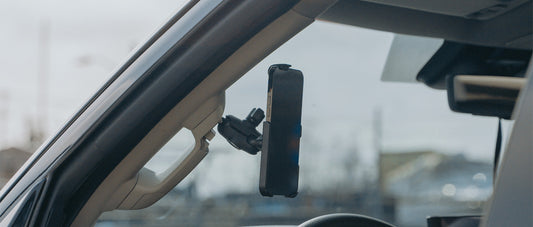 An iPhone 14 in a RAM form-fit holder secured to the grab handle of a Toyota Tundra