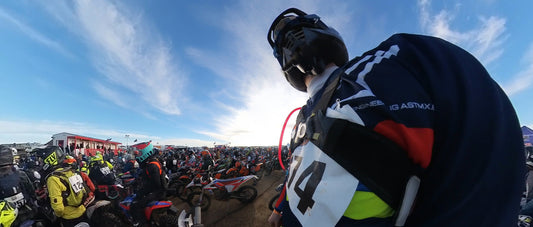 A man sitting on a dirt bike surrounded by thousands of other riders 
