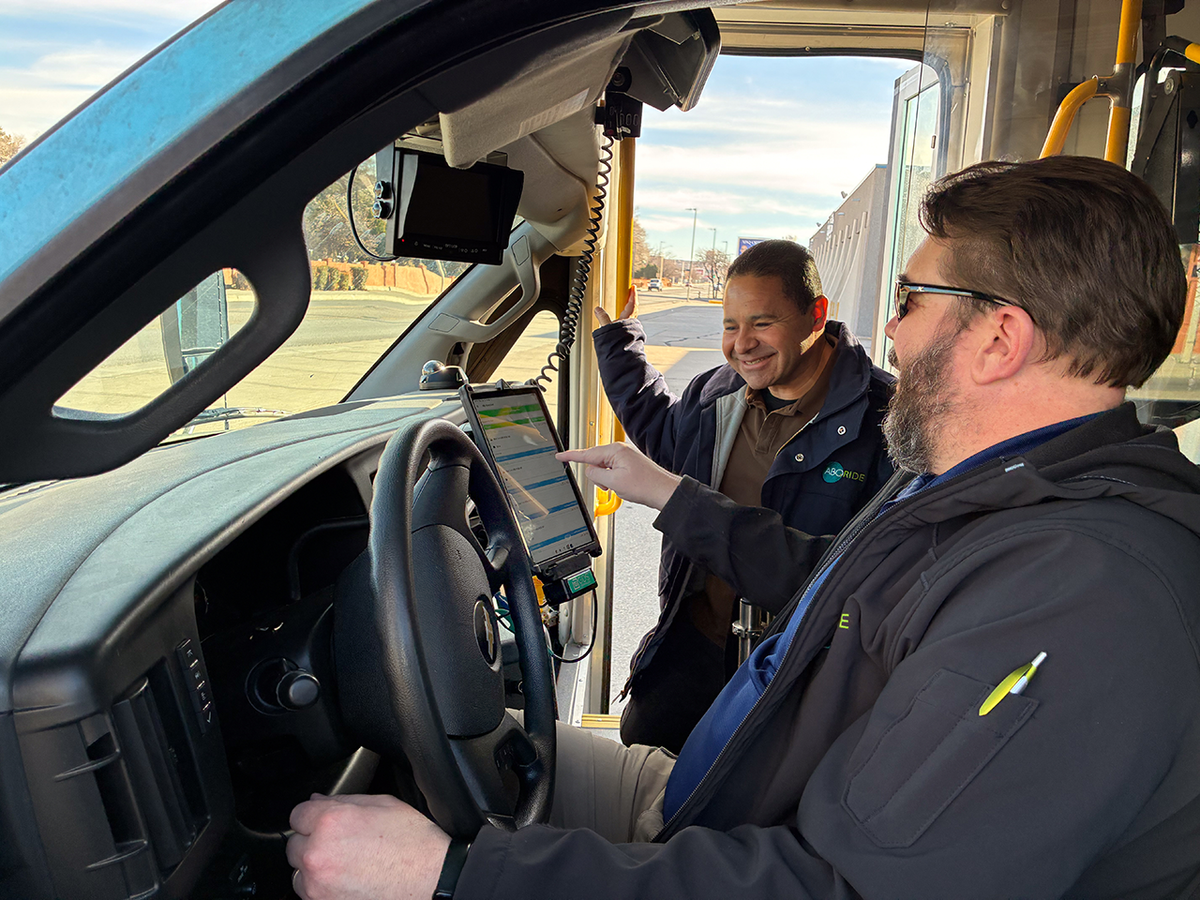 Image of ABQ RIDE team members interacting with  tablet mounted in fleet vehicle.