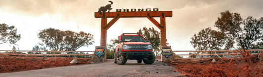 A Ford Bronco is posed in front of a wilderness area