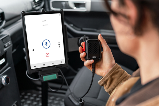 Woman holding RAM® RSM connected to a mounted  tablet in-vehicle for push-to-talk communication