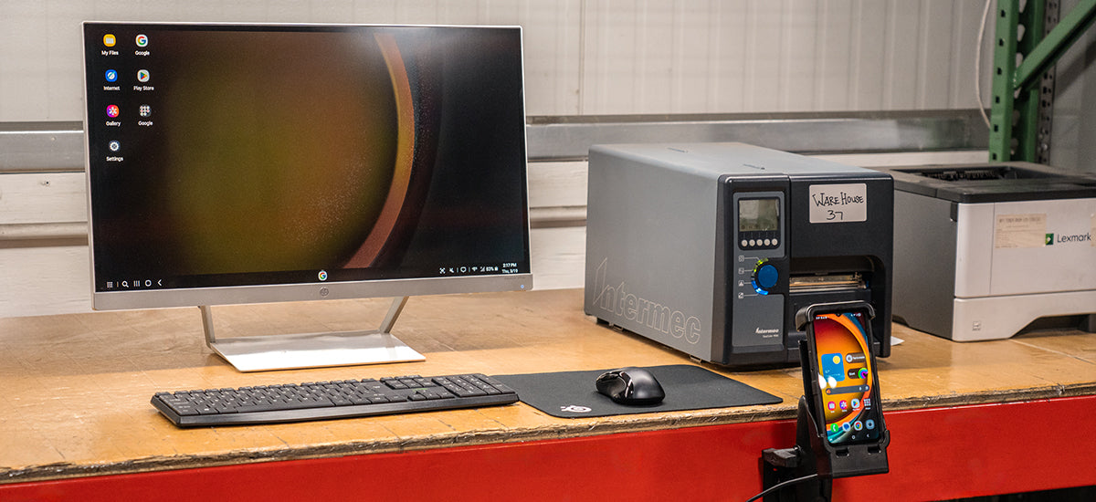 Samsung XCover7 Pro in RAM Mounts dock connected to monitor, keyboard, and peripherals running Samsung DeX workstation