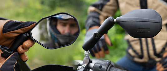 A man is adjusting his motorcycle mirrors, the RAM® Tough-Mirror™