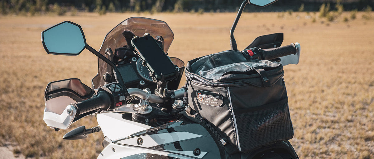 A close-up shot of a motorcycle parked in a brown field with a RAM Quick-Grip