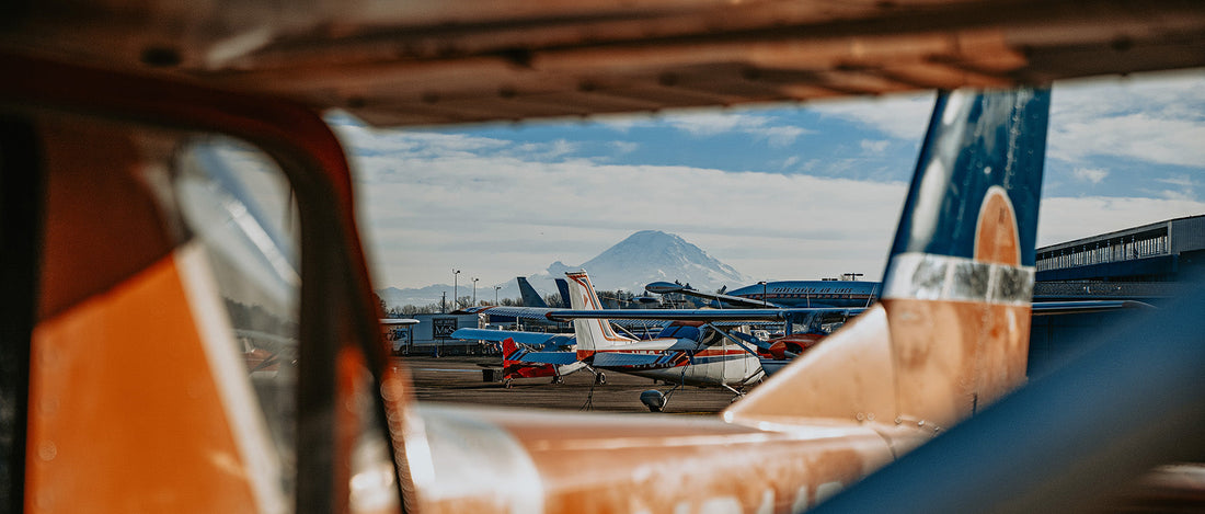 An airfield of small personal planes sit in the view of Mount Rainer