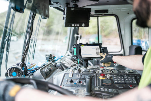 Man is reaching out to tap on a mounted tablet in GDS Tech and IntelliSkin inside a waste collection truck