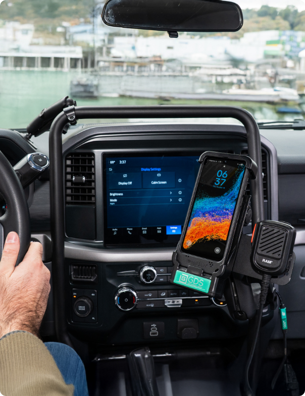 View of RAM® Tough-Bar™ that features a strategically placed connection point that secures the mount to the center dashboard. It also shows a Samsung device attached to the tough bar with a RAM push-to-talk mic. 