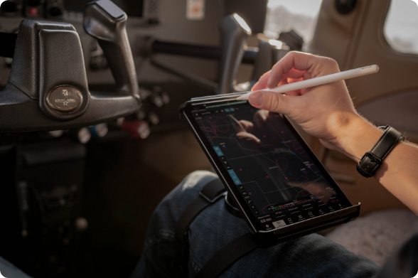 Pilot using Apple Pencil on iPad displaying flight planning or navigation interface secured in RAM® kneeboard mount, demonstrating hands-free electronic flight bag solution for in-flight data entry, chart annotation, and cockpit workflow management during commercial or general aviation operations.