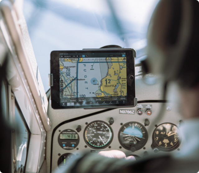 Tablet displaying detailed aviation sectional chart and navigation map for Seattle area secured in RAM® mount in small aircraft cockpit, positioned above instrument panel gauges for pilot reference during general aviation flight operations.