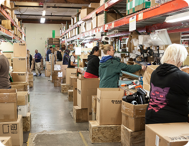 Multiple workers assembling products in a warehouse