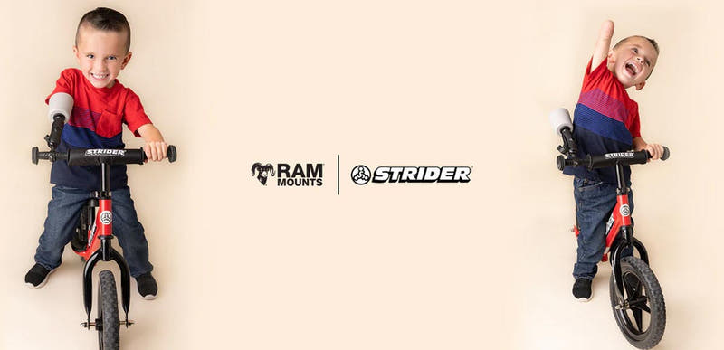 Promotional image featuring a child riding a red Strider™ balance bike equipped with an adaptive prosthetic arm support. The child is shown in two playful poses against a light neutral background, smiling and confidently riding the bike. RAM® Mounts and Strider™ logos appear in the center of the image, highlighting a collaboration focused on adaptive mobility solutions that help children with limb differences enjoy independent riding experiences.