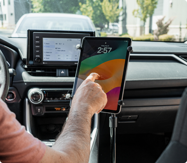 Image of man tapping on an iPad Pro mounted in a universal tablet holder mount in a car