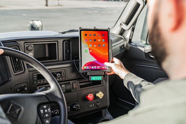 Person in a car interacting with electronic device mounted to dashboard using a RAM® mount