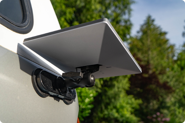 Starlink mini secured in RAM® magnetic mount system attached to recreational vehicle exterior wall, demonstrating portable computing solution for outdoor activities and camping with natural landscape background and RV travel applications.