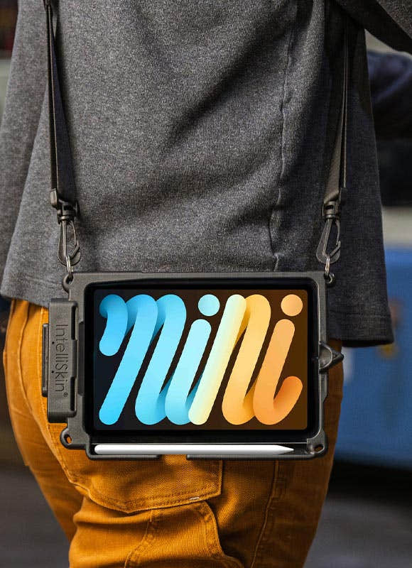 Tablet in a rugged IntelliSkin® protective case worn with a shoulder strap for hands-free mobility. The device is positioned at the user's side and features a stylus holder integrated into the case, providing easy access for data entry and note-taking. The wearable configuration supports mobile workflows in warehousing, logistics, retail, healthcare, field service, and industrial environments by keeping the tablet secure and readily accessible while on the move.